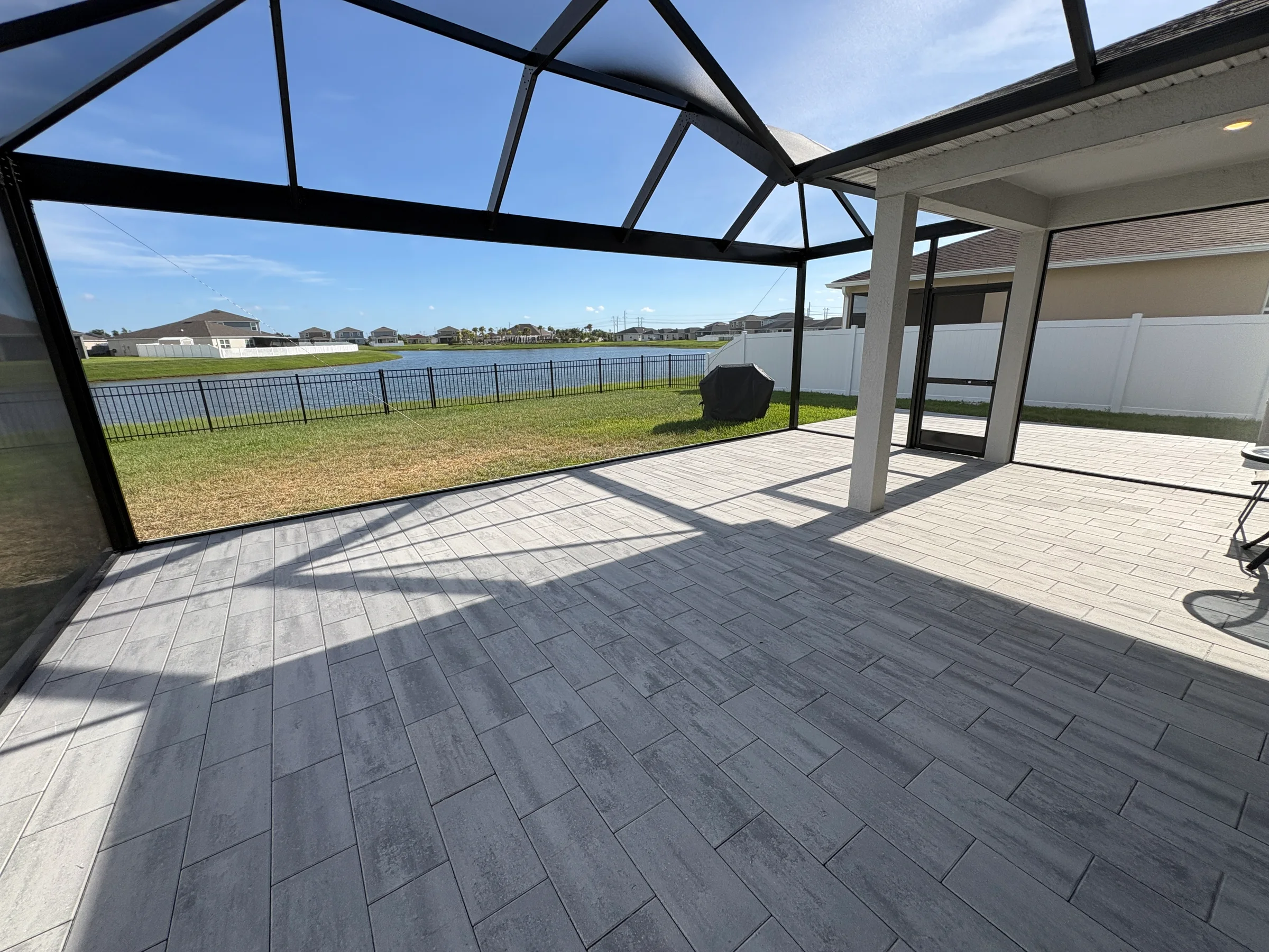 Black screen enclosure surrounding a finished paver patio